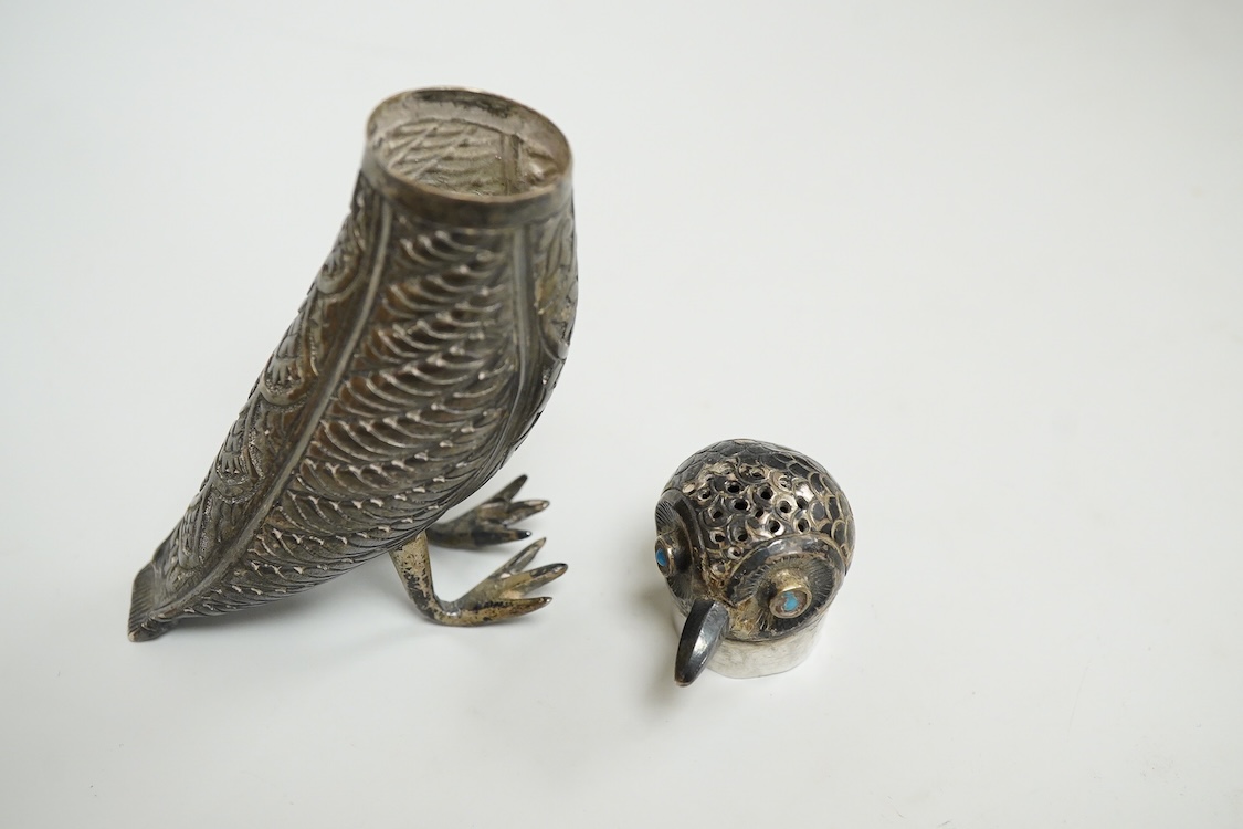 A novelty white metal pepperette, modelled as a free standing bird, with blue glass eyes, indistinct mark to one leg, height 87mm.
